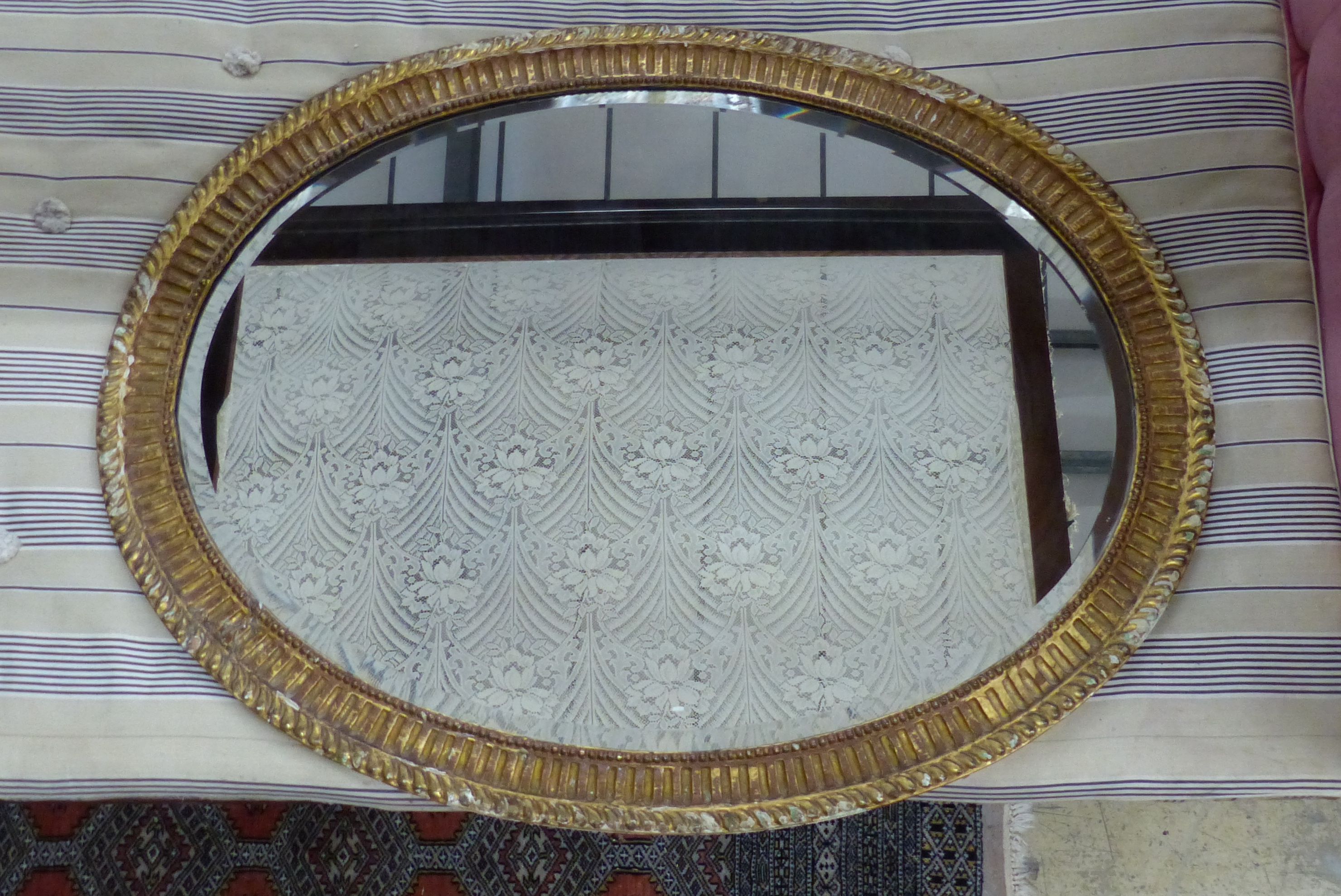 A large George III oval giltwood mirror, width 109cm, height 84cm